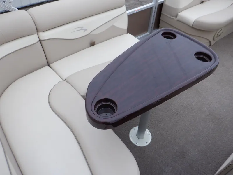 Slide: The Image of Bennington 22 SSL 2011 boat interior with beige seating and wooden table with cup holders. - 40
