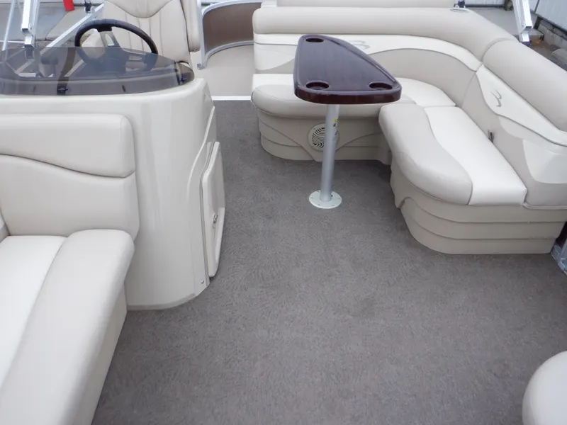 Slide: The Image of 2011 Bennington 22 SSL boat interior with beige seating and a small table. - 50
