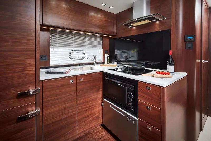 Slide: The Image of Luxurious kitchen interior of 2025 Princess V50 Open yacht, featuring modern appliances and wood cabinetry. - 9