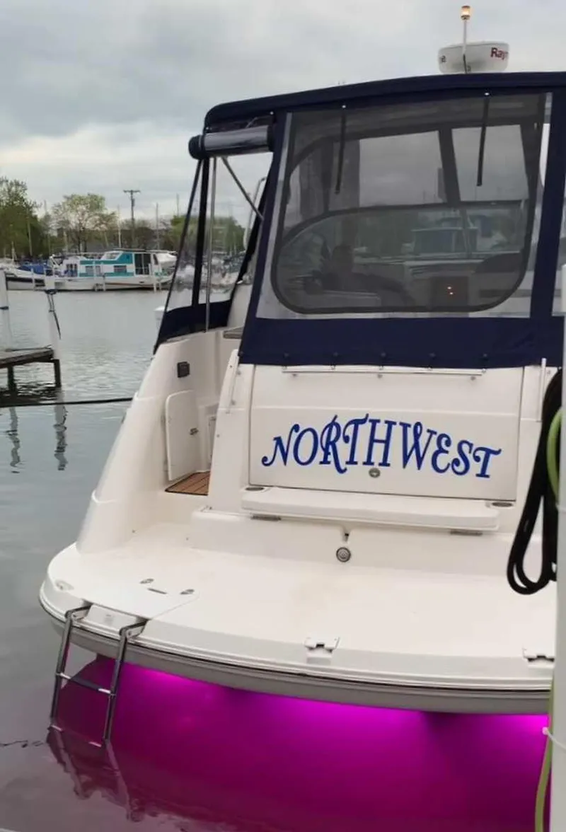 Slide: The Image of 2008 Rinker 330 Express Cruiser with "Northwest" name and purple underwater lights at marina. - 7