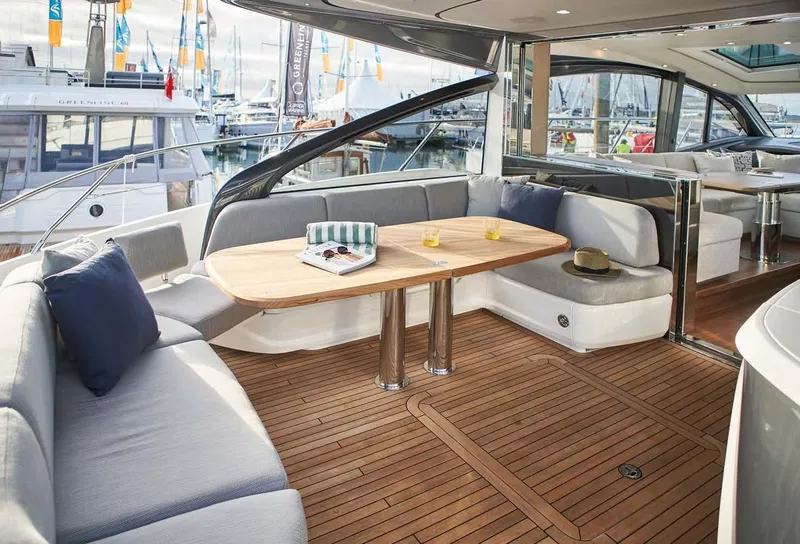 Slide: The Image of Luxurious 2025 Princess V55 Express yacht interior with elegant seating and wooden deck. - 10
