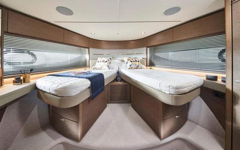 Slide: The Image of Luxurious 2025 Princess V55 Express yacht cabin with twin beds and modern decor. - 19