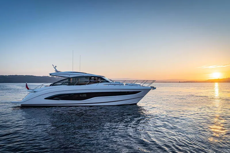 Slide: The Image of 2025 Princess V55 Express yacht cruising at sunset on calm waters. - 2