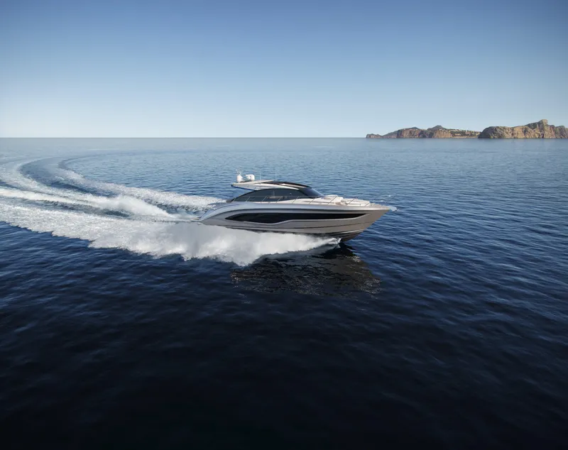 Slide: The Image of 2025 Princess V55 Express yacht cruising on open sea with distant islands. - 6