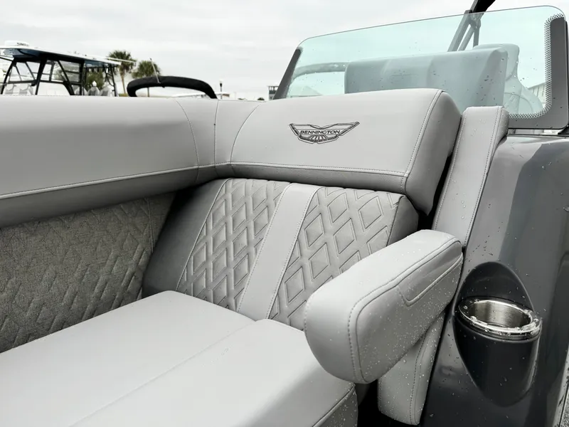 Slide: The Image of 2025 Bennington 22MSB boat interior with luxurious gray seating and diamond stitching. - 18