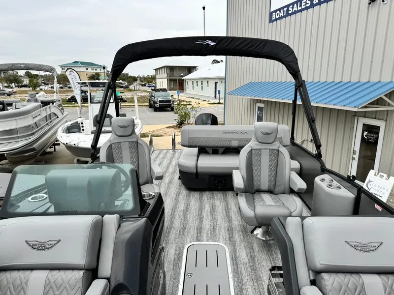 Slide: The Image of 2025 Bennington 22MSB pontoon boat with luxurious seating at a boat sales dealership. - 24