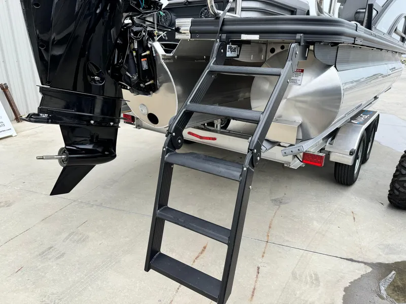 Slide: The Image of 2025 Bennington 22MSB boat with ladder and outboard motor on trailer. - 28