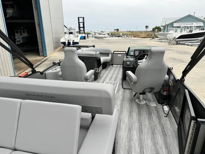 Slide: The Image of 2025 Bennington 22MSB pontoon boat interior with gray seating and modern dashboard. - 6