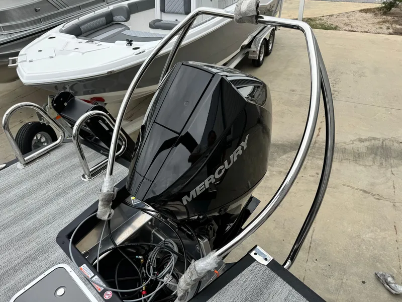 Slide: The Image of 2025 Bennington 22MSB with Mercury outboard motor, parked on a trailer. - 7