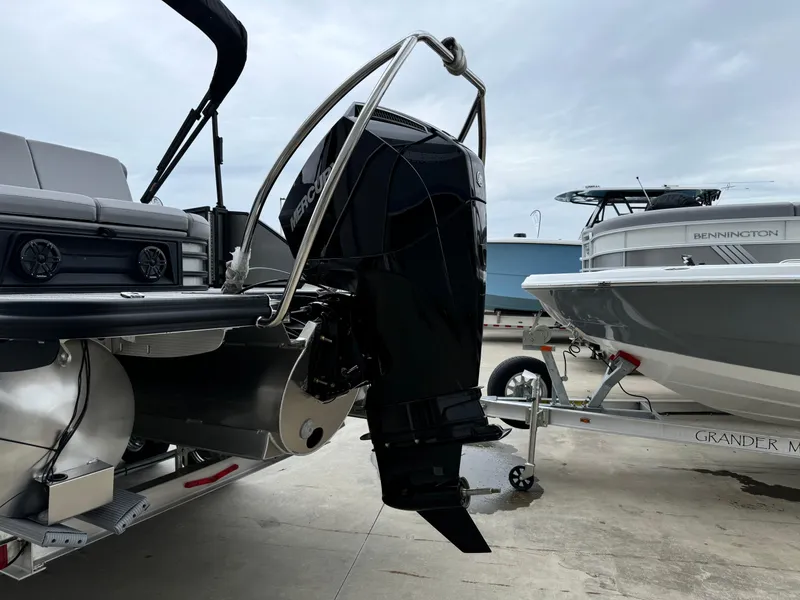 Slide: The Image of 2025 Bennington 22MSB pontoon boat with powerful outboard motor, docked beside another boat. - 8