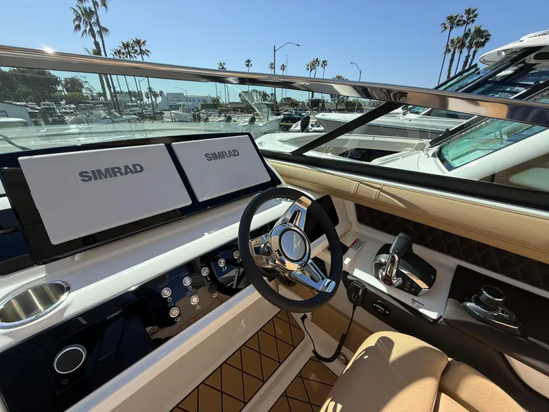 Slide: The Image of 2025 Sea Ray SLX 310 OB boat cockpit with dual Simrad displays and luxurious seating. - 13