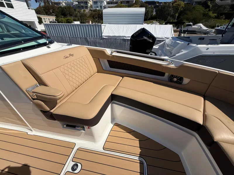 Slide: The Image of 2025 Sea Ray SLX 310 OB boat with tan leather seating and teak flooring. - 17