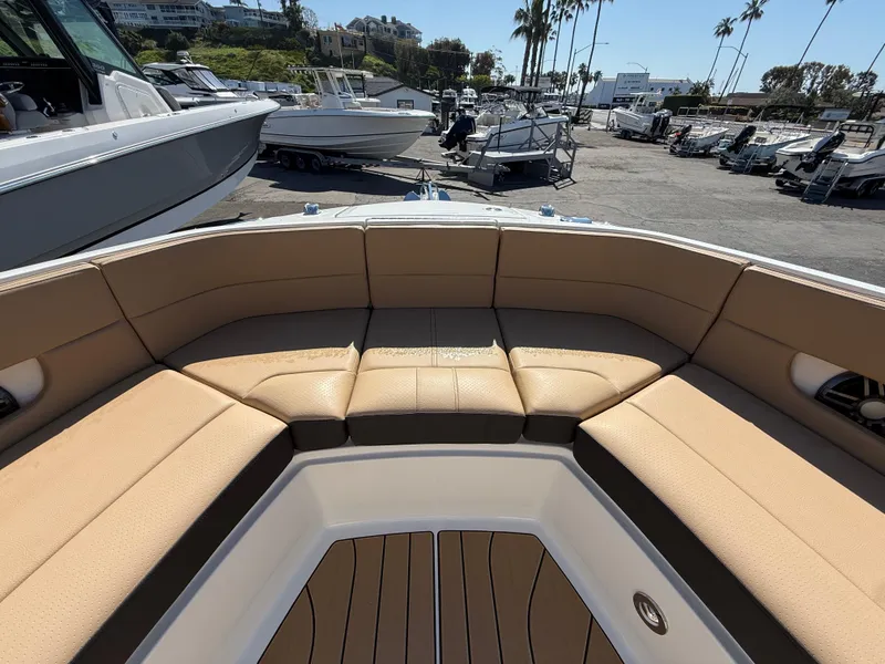 Slide: The Image of 2025 Sea Ray SLX 310 OB boat with tan seating in a marina setting. - 18