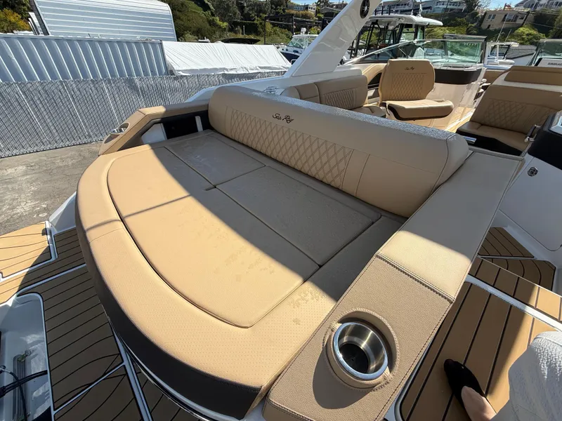 Slide: The Image of 2025 Sea Ray SLX 310 OB boat with luxurious tan seating and cup holder. - 6