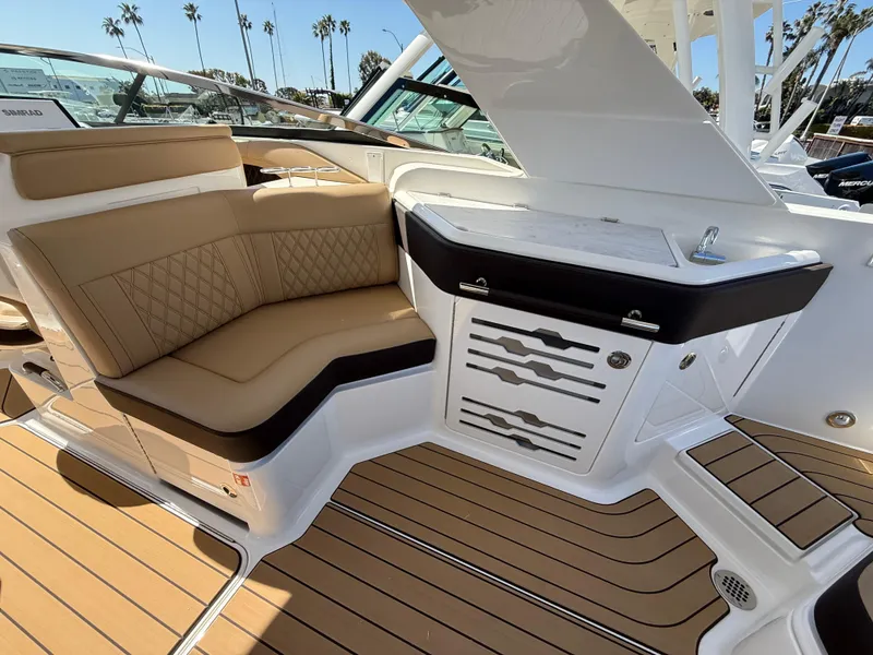 Slide: The Image of 2025 Sea Ray SLX 310 OB boat interior with tan seating and sleek cabinetry. - 9