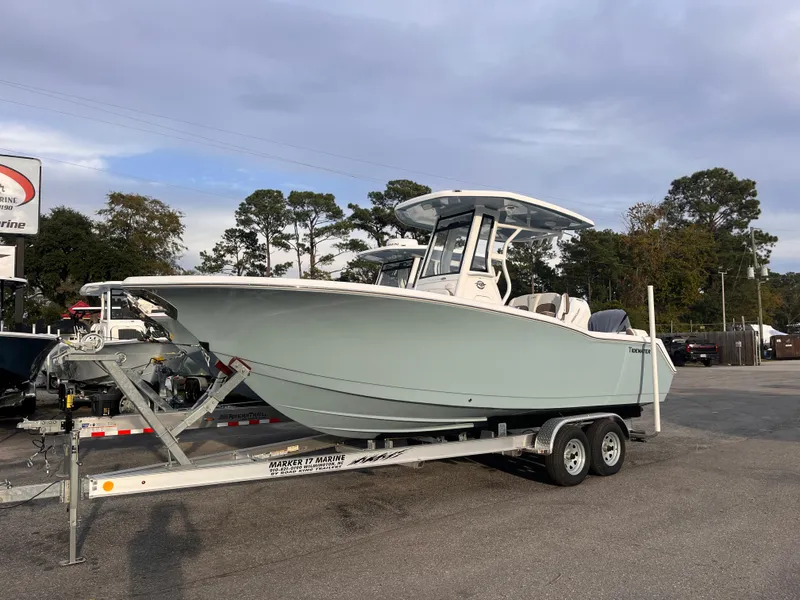 Slide: The Image of 2025 Tidewater 232 LXF boat on trailer, parked outdoors. - 2