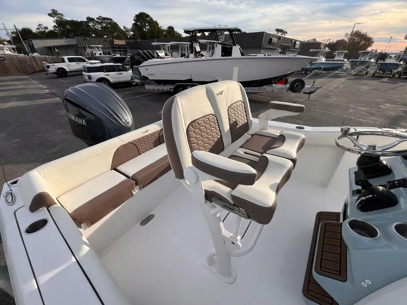Slide: The Image of 2025 Tidewater 232 LXF boat interior with seating and Yamaha engine in a marina setting. - 7