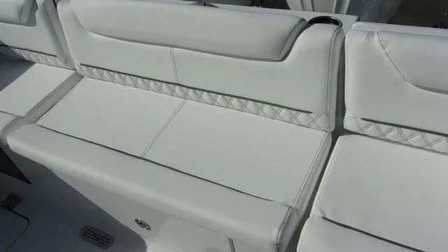 Slide: The Image of 2025 Sportsman Heritage 261 boat seating with white cushioned upholstery and diamond stitching. - 16