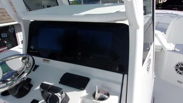 Slide: The Image of 2025 Sportsman Heritage 261 boat dashboard with dual screens and steering wheel. - 7