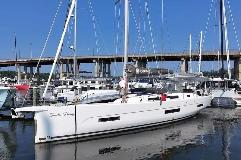 The Image of 2022 Dufour 530 sailboat docked at marina under clear blue sky. - 1