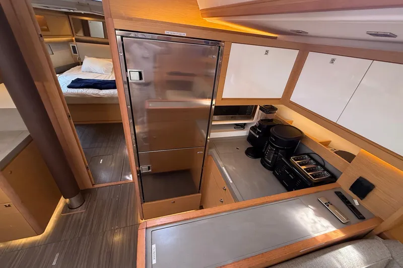 Slide: The Image of Modern kitchen interior of 2022 Dufour 530 yacht with appliances and cozy bedroom view. - 12