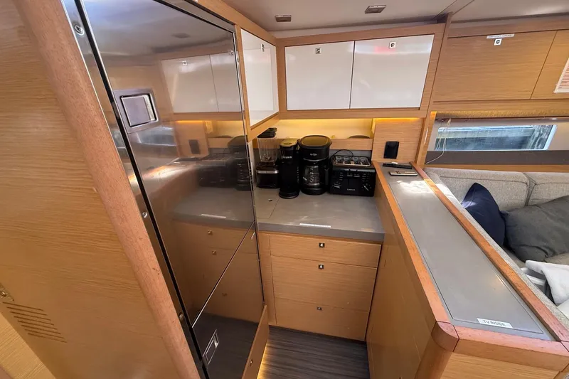 Slide: The Image of Modern kitchen interior of 2022 Dufour 530 yacht with appliances and wooden cabinetry. - 17
