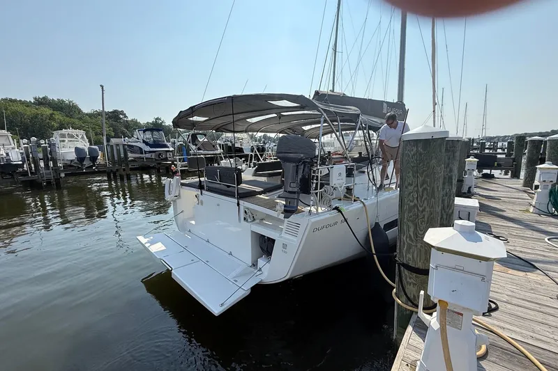 Slide: The Image of 2022 Dufour 530 yacht docked at marina, featuring spacious deck and canopy. - 3