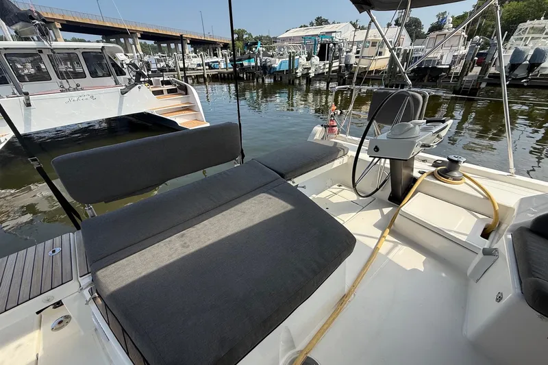 Slide: The Image of 2022 Dufour 530 yacht cockpit with seating and steering wheel, docked at marina. - 34