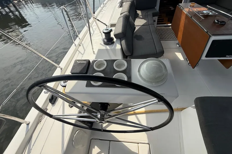 Slide: The Image of Cockpit of 2022 Dufour 530 sailboat with steering wheel and seating area. - 35