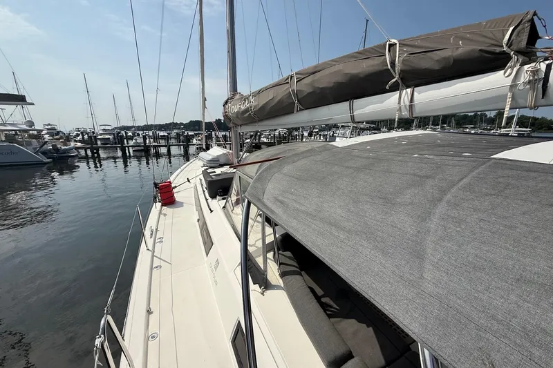 Slide: The Image of 2022 Dufour 530 sailboat docked at marina, showcasing deck and sail details. - 37