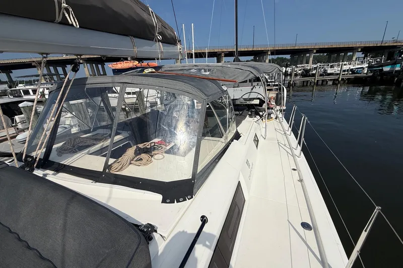 Slide: The Image of 2022 Dufour 530 sailboat docked at marina, featuring sleek design and covered cockpit. - 40
