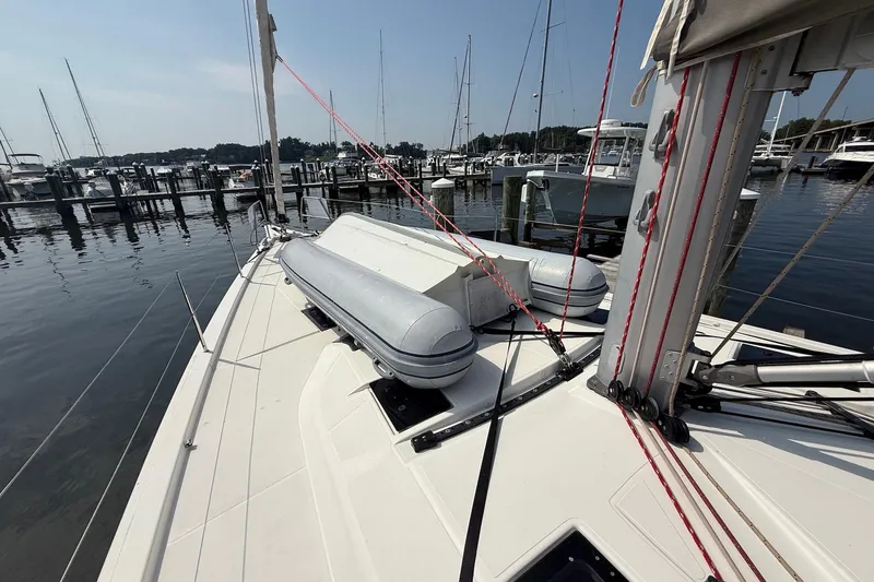 Slide: The Image of 2022 Dufour 530 sailboat deck with lifeboats, docked at a marina. - 41