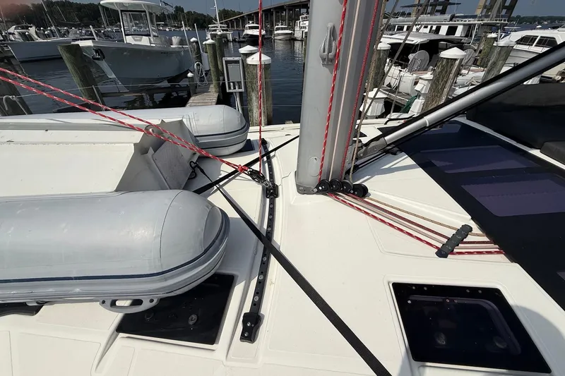Slide: The Image of Dufour 530 sailboat deck with rigging and inflatable dinghy, docked at marina, 2022 model. - 42