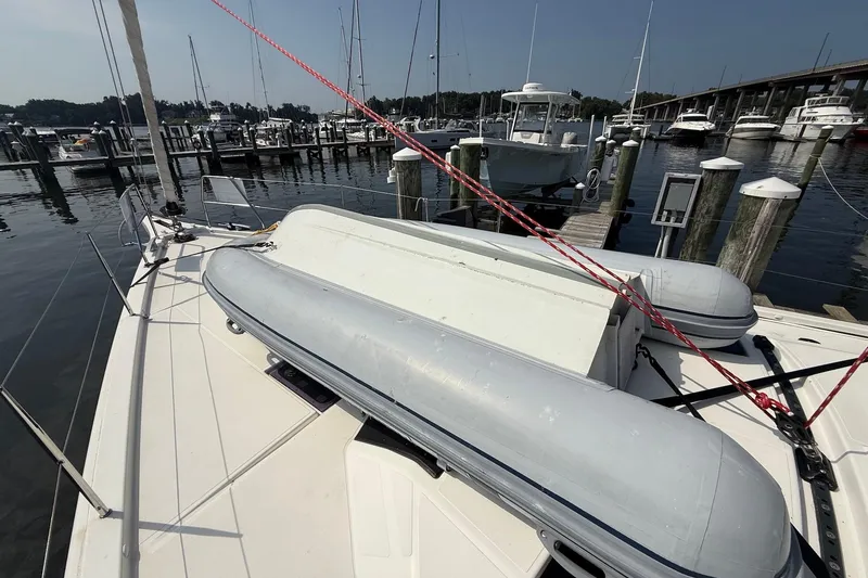 Slide: The Image of 2022 Dufour 530 sailboat docked, featuring deck view with inflatable dinghy. - 43