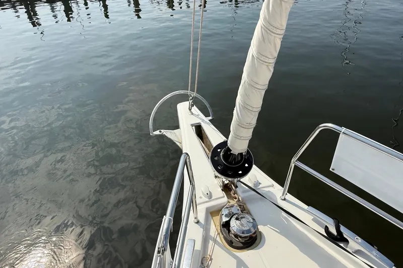 Slide: The Image of Bow of 2022 Dufour 530 sailboat with wrapped sail, docked on calm water. - 44