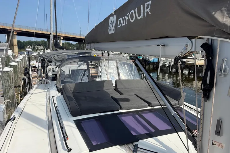 Slide: The Image of 2022 Dufour 530 sailboat docked, featuring spacious deck and modern design. - 46