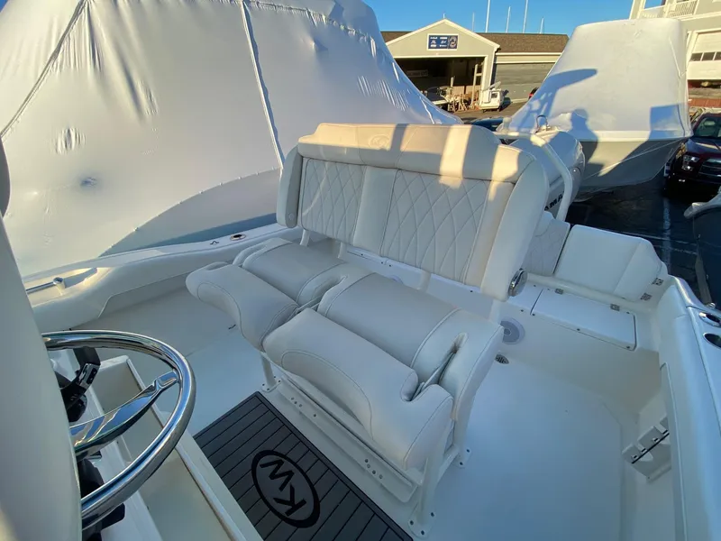 Slide: The Image of 2025 Key West 219 FS boat interior with white seating and steering wheel. - 11