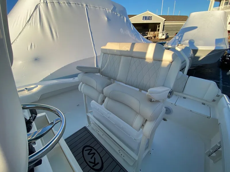 Slide: The Image of 2025 Key West 219 FS boat interior with white seating and steering wheel. - 12