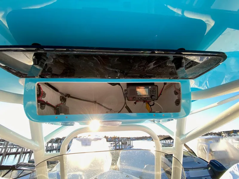 Slide: The Image of 2025 Key West 219 FS boat console with electronic equipment, docked under clear blue sky. - 4