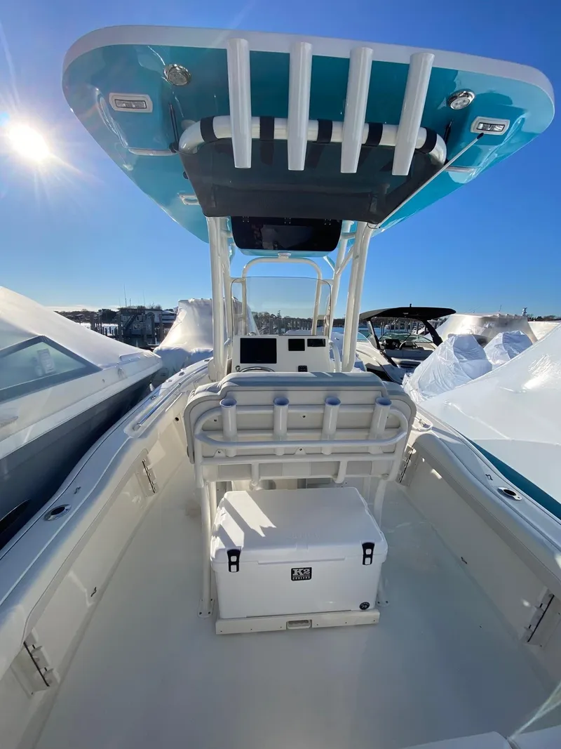 Slide: The Image of 2025 Key West 219 FS boat interior with T-top and seating, under clear blue sky. - 5