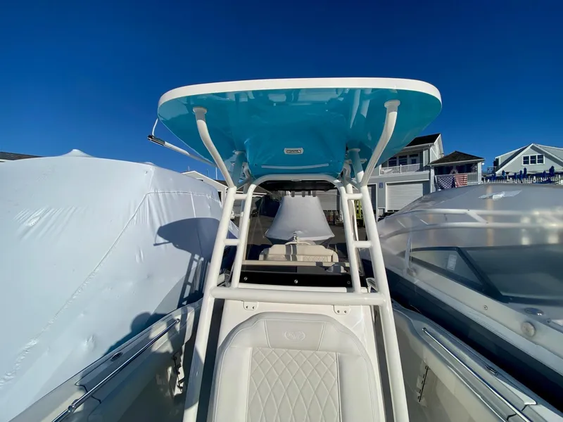 Slide: The Image of 2025 Key West 219 FS boat with T-top, docked under clear blue sky. - 8