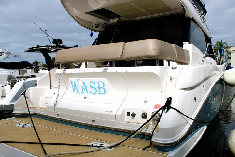 Slide: The Image of 2018 Regal 42 Fly yacht docked, featuring spacious deck and elegant design. - 16