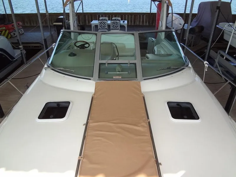 Slide: The Image of 2000 Sea Ray 340 Sundancer boat docked, featuring a spacious deck and windshield. - 13