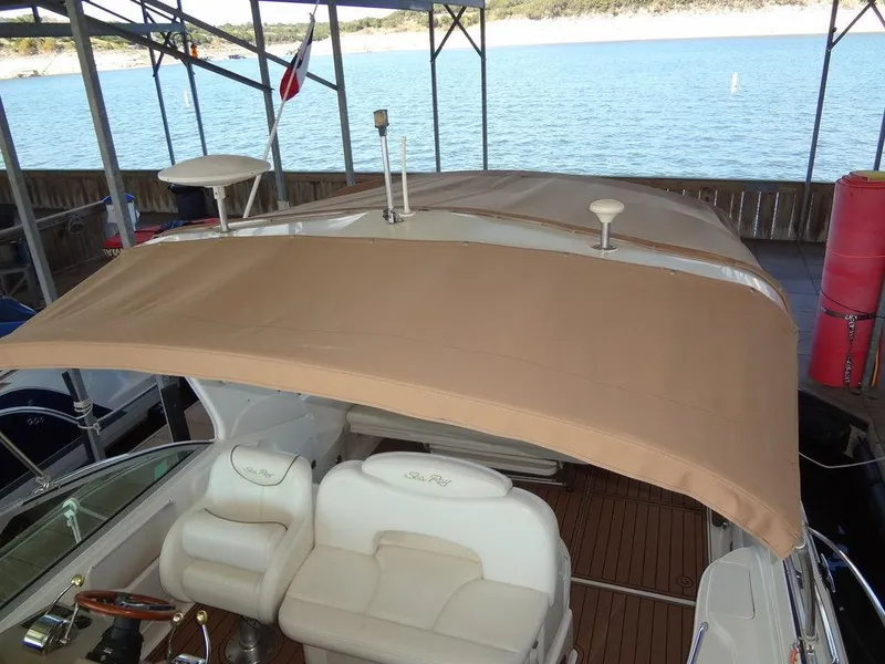 Slide: The Image of 2000 Sea Ray 340 Sundancer with beige canopy docked by a lake. - 15