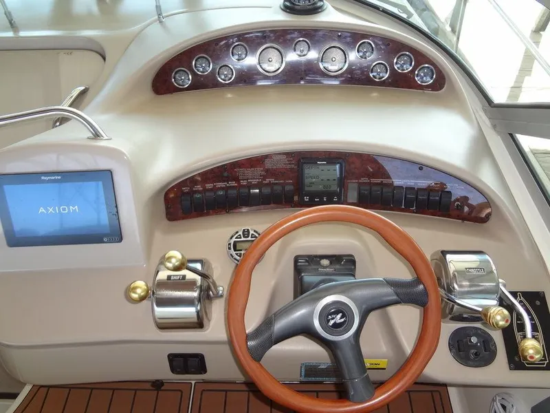 Slide: The Image of Sea Ray 340 Sundancer 2000 helm with steering wheel, gauges, and navigation display. - 24