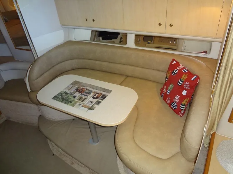 Slide: The Image of Interior of 2000 Sea Ray 340 Sundancer with beige seating and red decorative pillow. - 28