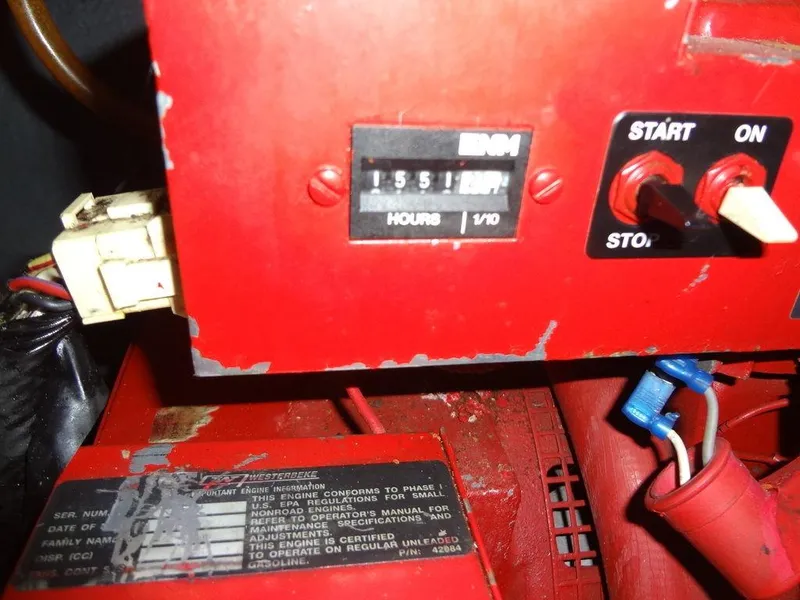 Slide: The Image of Close-up of a red engine control panel with hour meter and switches. - 49