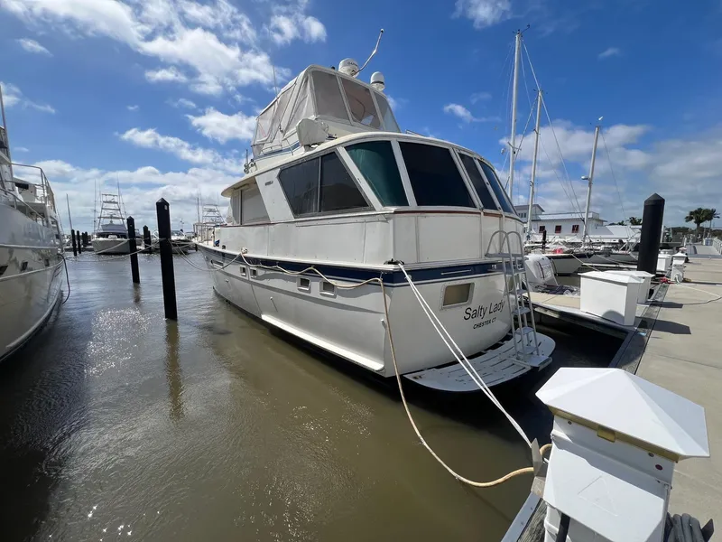 Slide: The Image of 1979 Hatteras 53 Motor Yacht docked at marina under blue sky. - 1