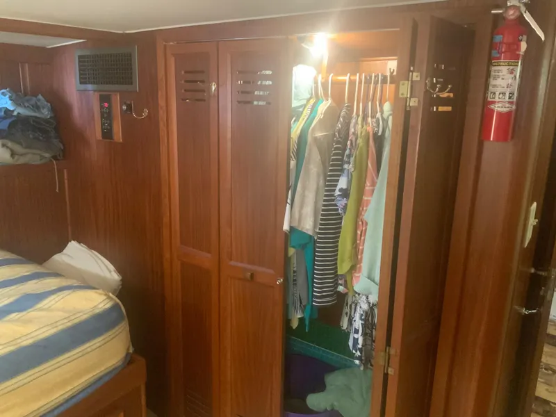 Slide: The Image of 1979 Hatteras 53 Motor Yacht interior with wooden closet and hanging clothes. - 10