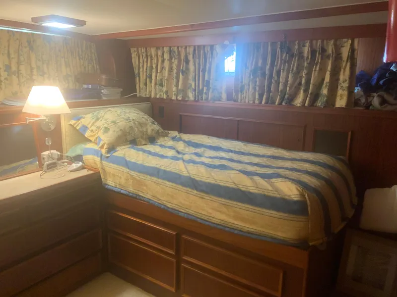Slide: The Image of Cozy cabin interior of 1979 Hatteras 53 Motor Yacht with striped bedding and floral curtains. - 13